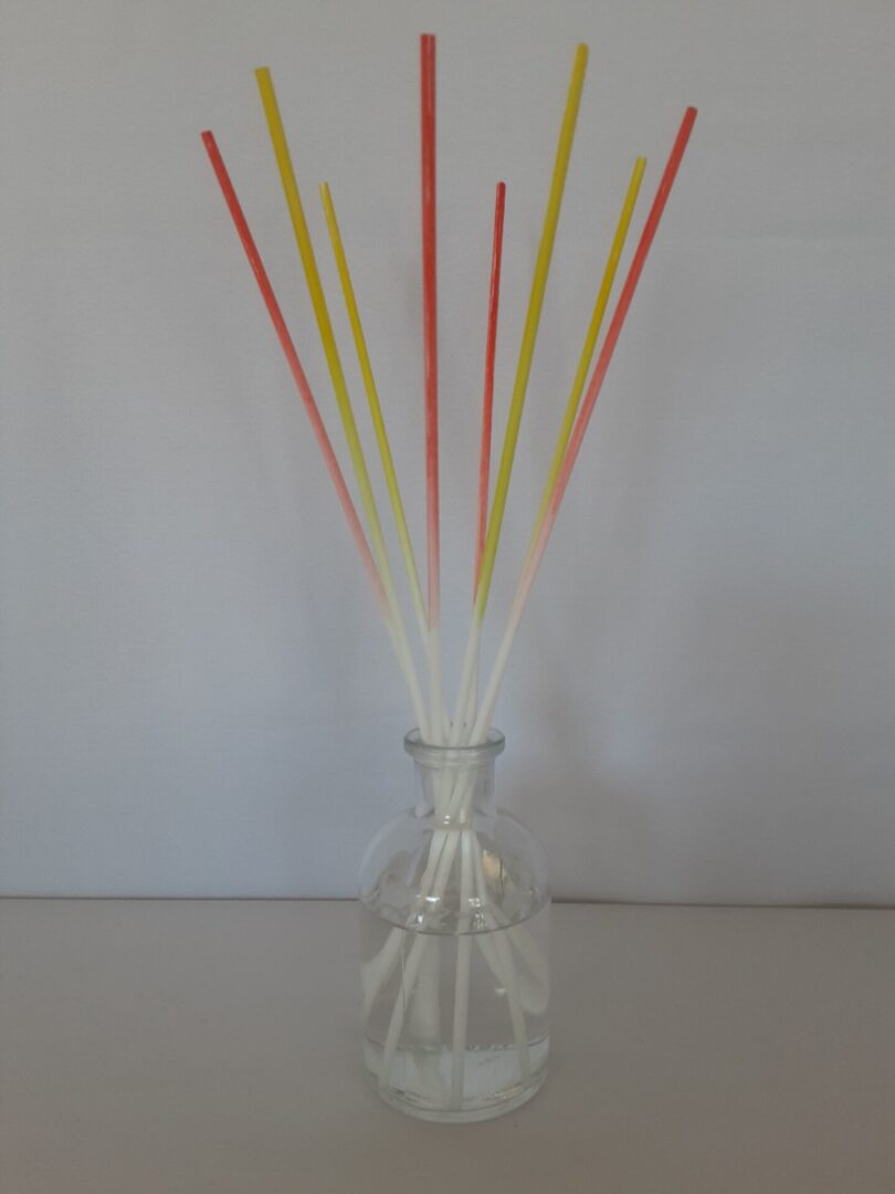 A vase with many colored sticks in it