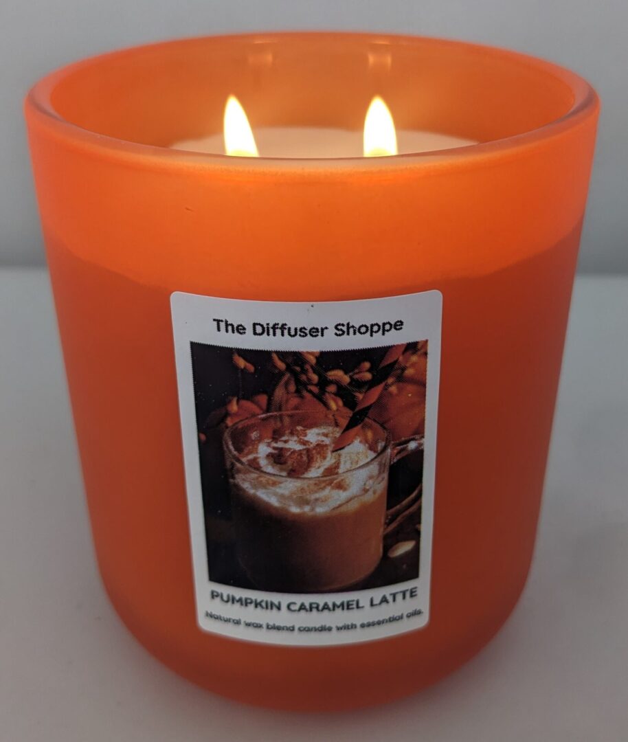 A candle that has been lit with the picture of a pumpkin.