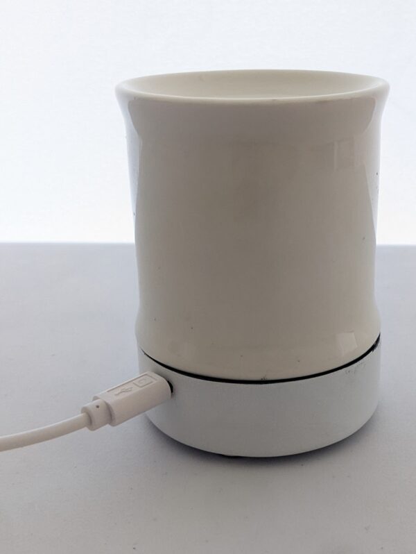 A white cup with a usb cable plugged in.