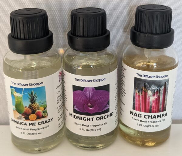 Three different bottles of fragrance oils sitting on a table.