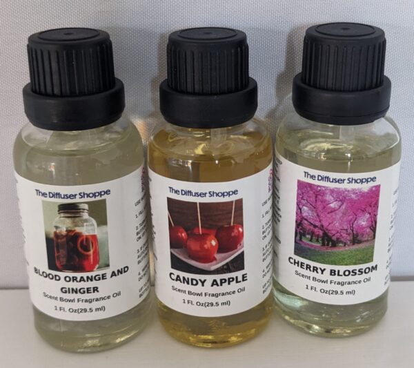 Three bottles of fragrance oils are sitting on a table.