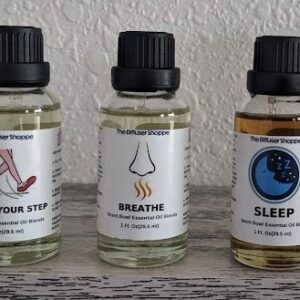 Three bottles of oils are sitting on a shelf.
