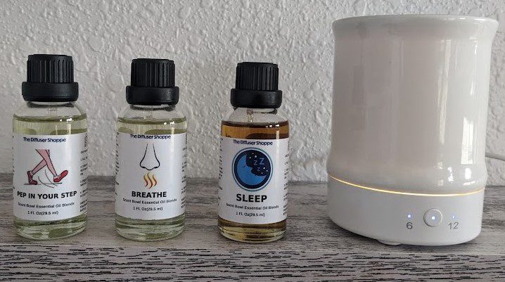 Two bottles of essential oils sitting next to a humidifier.