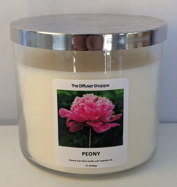 A large candle with a picture of a pink flower.